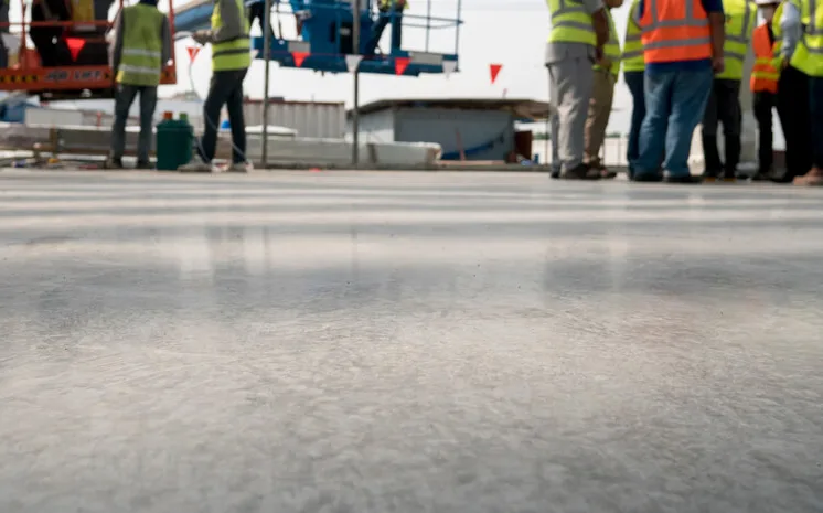 piso resinado em uma fábrica com trabalhadores ao fundo